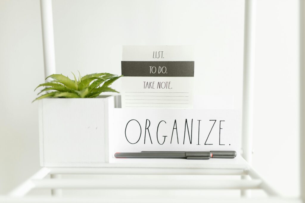 A minimalist setup featuring a to-do list, plant, and pens for organized productivity.
